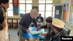 Businessman Imran Sheikh, 52, registers to vote at a polling station in a school on the day of the general election, in Islamabad, Feb. 8, 2024.