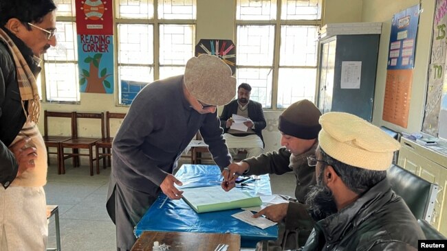 Businessman Imran Sheikh, 52, registers to vote at a polling station in a school on the day of the general election, in Islamabad, Feb. 8, 2024.