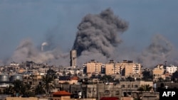 This picture taken from Rafah, in the southern Gaza Strip, shows smoke rising over buildings in Khan Yunis during Israeli bombardment on Feb. 1, 2024.