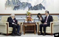 In this photo released by China's Ministry of Foreign Affairs, former Secretary of State Henry Kissinger, left, meets with Chinese State Councilor Wang Yi in Beijing, Wednesday, July 19, 2023.