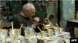 A craftsman person engraving an object in an alley in the Medina of Tunis, Tunisia on December 8, 2023