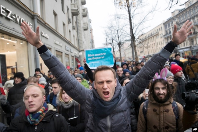 FILE - Russian opposition leader Alexei Navalny, center, attends a rally in Moscow, Russia, on Jan. 28, 2018. (AP Photo/Evgeny Feldman, File)