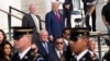 Republican presidential nominee former President Donald Trump, top right, watches the changing of the guard at the Tomb of the Unknown Solider at Arlington National Cemetery, in Arlington, Virginia, Aug. 26, 2024. 