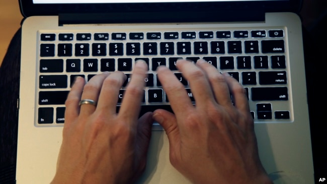 FILE - This Monday, June 19, 2017, photo shows fingers on a laptop keyboard in North Andover, Mass. (AP Photo/Elise Amendola)