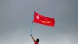 Một người ủng hộ vươn cờ Liên đoàn Quốc gia vì Dân chủ (NLD) của bà Aung San Suu Kyi.