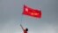 FILE - A supporter of National League for Democracy party holds a flag from a boat in the Yangon river, Myanmar, Oct. 28, 2020. 