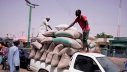 Des travailleurs déchargent des sacs de céréales d'un camion sur le marché de Gombe, au Nigeria, le 3 juin 2024.