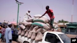 FILE - Workers offload bags of grains from a truck at a market in Gombe, Nigeria, June 3, 2024. 