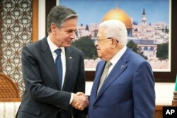 FILE - U.S. Secretary of State Antony Blinken, left, and Palestinian President Mahmoud Abbas shake hands during their meeting in the West Bank town of Ramallah, February 7, 2024.