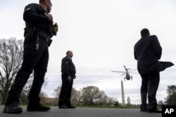 FILE - Members of the Secret Service stand guard as Marine One with President Joe Biden aboard lifts off from the South Lawn of the White House in Washington, March 22, 2024, to travel to Wilmington, Delaware.