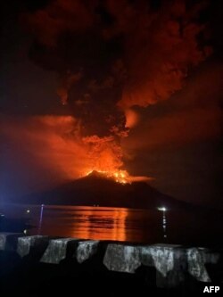 Gunung Ruang mengeluarkan lahar panas dan asap di Kepulauan Sangihe dilihat dari Sitaro, Sulawesi Utara, 17 April 2024. (Handout / Center for Mitigasi Vulkanologi dan Bahaya Geologi / AFP)
