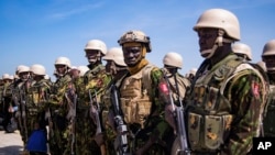 Members of a police force from Kenya stand on the tarmac of Toussaint Louverture International Airport after landing in Port-au-Prince, Haiti, June 25, 2024. 