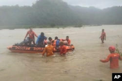 In this handout photo provided by the Philippine Coast Guard, rescuers use a rubberboat to evacuate quarry workers trapped in Naguilian, La Union province, northern Philippines on July 26, 2023.