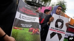 Aktivis membawa poster saat unjuk rasa menolak pembatalan Piala Dunia FIFA U-20, di Jakarta, Jumat, 31 Maret 2023. (Foto: AP/Dita Alangkara)