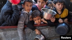 Anak-anak Palestina antre untuk menerima bantuan makanan yang dimasak oleh dapur amal di tengah kekurangan pasokan makanan di Rafah, di selatan Jalur Gaza, 5 Februari 2024.