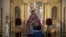 FILE - A father and his son look at a figure of Jesus Christ at San Esteban church, in Seville, Spain, on March 30, 2021. 