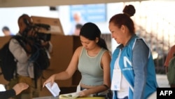 A woman casts her vote during the presidential and legislative elections at a polling station in San Salvador on Feb. 4, 2024.