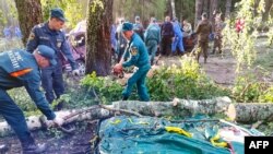 রাশিয়ার মারি এল প্রজাতন্ত্রের ইয়ালচিক হ্রদে ঝড়ো বাতাসে একটি তাঁবুর ক্যাম্পে গাছ পড়ে যাওয়ার পরে ঘটনাস্থলে উদ্ধার কাজ করছে জরুরী কর্মীরা। ৩০ জুলাই, ২০২৩। 