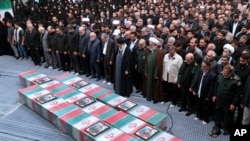 2024年4月4日，在德黑蘭，伊朗最高領袖哈梅內伊（中戴黑色頭巾者），在以色列空襲敘利亞中喪生的革命衛隊成員的靈柩前祈禱。 （美聯社照片）