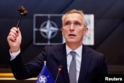 FILE - NATO Secretary General Jens Stoltenberg holds a gavel as he attends a meeting of the North Atlantic Council in the NATO defense ministers' session at the Alliance's headquarters in Brussels, Belgium, Feb. 15, 2024