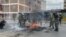 Riot police extinguish burning tires in Nairobi, Kenya, July 19, 2023. (Mariama Diallo/VOA)