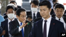 Japanese Prime Minister Fumio Kishida, left, surrounded by security police, arrives at the Saikazaki port for an election campaign event in Wakayama, western Japan April 15, 2023. 