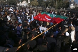 Supporters of former Pakistani Prime Minister Imran Khan's party block a road as a protest against the delayed result of parliamentary elections by the Pakistan Election Commission, in Peshawar, Pakistan, Feb. 9, 2024.