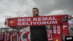 A vendor sells scarfs reading "I am Kemal, I am coming" during a rally of Turkey's Republican People's Party (CHP) Chairman and Presidential candidate Kemal Kilicdaroglu in Canakkale, western Turkey, on April 11, 2023.