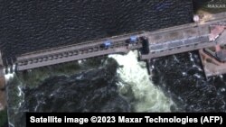 This handout satellite image courtesy of Maxar technologies shows a closer view of a destroyed roadway and section of the Nova Khakovka dam in south Ukraine, June 5, 2023. "AFP PHOTO / Satellite image ©2023 Maxar Technologies" 
