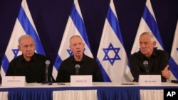 ARCHIVO - De izquierda a derecha, el primer ministro israelí, Benjamin Netanyahu, el ministro de Defensa, Yoav Gallant, y el ministro del gabinete, Benny Gantz, captados durante una conferencia de prensa en la base militar de Kirya, en Tel Aviv, el 28 de octubre de 2023.