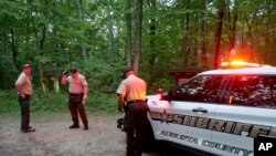 Las autoridades vigila la entrada a Mine Bank Trail, un punto de acceso a la operación de rescate a lo largo de Blue Ridge Parkway donde un Cessna Citation se estrelló sobre un terreno montañoso cerca de Montebello, Virginia, el domingo 4 de junio de 2023. (Randall K. Wolf vía AP)