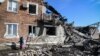 A woman walks past a ruined building after a missile strike in the town of Panteleimonovka in a Russian-controlled part of Donetsk region on Feb. 17, 2024, amid the ongoing Russian-Ukrainian conflict.