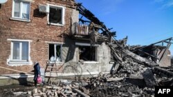 A woman walks past a ruined building after a missile strike in the town of Panteleimonovka in a Russian-controlled part of Donetsk region on Feb. 17, 2024, amid the ongoing Russian-Ukrainian conflict.