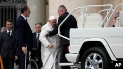 Pope Francis is being helped to get onto his car at the end of a weekly general audience in St. Peter's Square, at the Vatican, March 29, 2023.