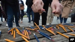 Journalists breaks pencils during a protest outside the parliament during the session about controversial amendments to the criminal code that would make defamation a crime punishable with stiff fines, in the Bosnian town of Banja Luka, March 14, 2023. 