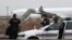 French customs officers stand next to a customs car with an Airbus A340 in the background which was grounded on the tarmac since Dec. 21 over suspected 'human trafficking', at the Vatry airport, Dec. 25, 2023. 