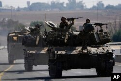 Israeli armored personnel carriers and tanks move towards the Gaza Strip border in southern Israel, Nov.1, 2023.