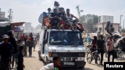 Palestinians, who fled the eastern part of Khan Younis after they were ordered by Israeli army to evacuate their neighborhoods, ride on a vehicle loaded with belongings, amid Israel-Hamas conflict, in Khan Younis in the southern Gaza Strip, July 2, 2024. 