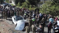 Lebanese army soldiers gather around a damaged car near the coastal town of Jadra, south Lebanon, Feb. 10, 2024. 