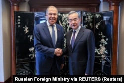 Menlu Rusia Sergei Lavrov berjabat tangan dengan Direktur Kantor Komisi Luar Negeri Pusat China Wang Yi di sela-sela pertemuan Menlu ASEAN di Jakarta, 13 Juli 2023. (Foto: via Reuters)