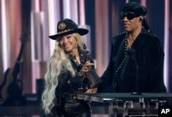 Beyonce (kiri), menerima Innovator Award saat presenter Stevie Wonder tampil di iHeartRadio Music Awards di Dolby Theatre, Los Angeles, Senin, 1 April 2024. (AP/Chris Pizzallo)