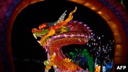 A man walks past a dragon figure at a lunar new year&#39;s fair in Beijing, China.