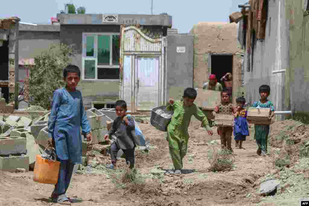 کودکان در ساحهٔ خیرآباد ولایت غزنی پس از سیلاب تلاش دارند تا اموال خانه&zwnj;هایشان را جمع&zwnj;آوری کنند.