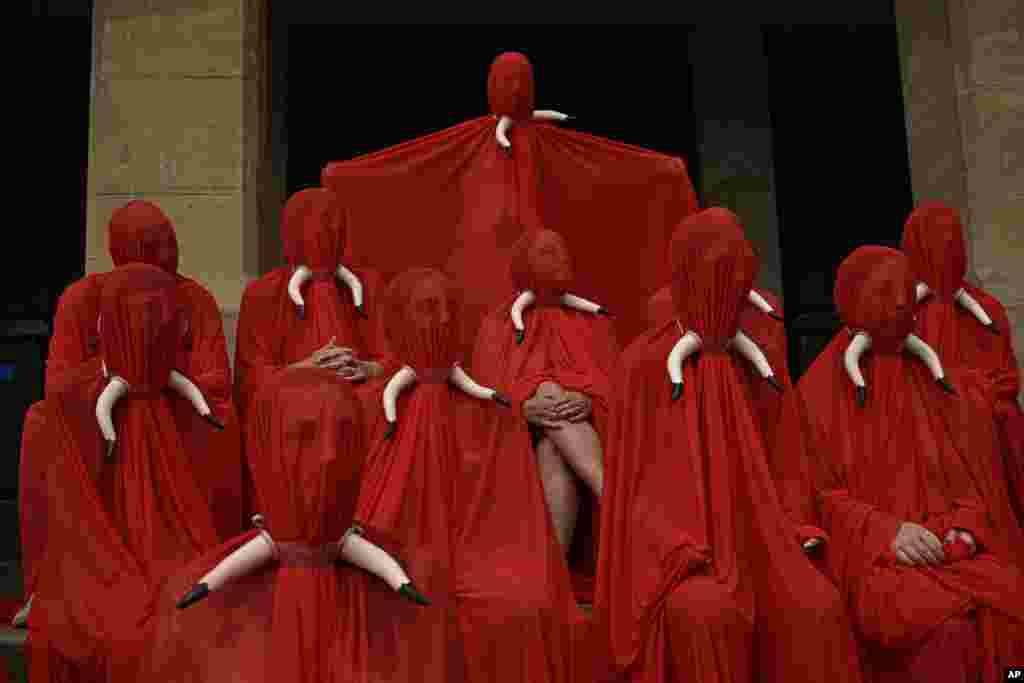 Orang-orang berselimut kain merah, warna festival San Fermin, untuk memrotes perlakuan kejam terhadap hewan khususnya banteng, menjelang festival San Fermin, di kota Pamplona, Spanyol. (AP)&nbsp;