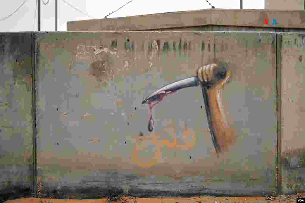 Grafiti de un cuchillo ensangrentado en una de las paredes de Little Gaza. El centro de entrenamiento ha sido acondicionado para simular lo más real posible a una ciudad árabe, según las Fuerzas de Defensa de Israel.&nbsp;