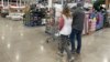 FILE - Shoppers pass displays of goods in a Costco warehouse Sheridan, Colorado, Feb. 25, 2024. With less than four months to go before Election Day, U.S. voters are prioritizing the health of their wallets and pocketbooks.