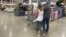 FILE - Shoppers pass displays of goods in a Costco warehouse Sheridan, Colorado, Feb. 25, 2024. With less than four months to go before Election Day, U.S. voters are prioritizing the health of their wallets and pocketbooks.