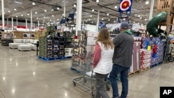 资料照片：2024年2月25日，在科罗拉多州谢里登的开市客 (Costco )仓库中，购物者们走过展示的商品。(美联社照片)

