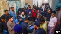 Seorang personel polisi melakukan uji biometrik terhadap para pengungsi Afghanistan dalam sebuah operasi penertiban untuk mengidentifikasi terduga imigran ilegal di perbatasan di Karachi, Pakistan, 17 November 2023. (Foto: Photo by Asif Hassar/ AFP)