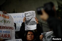 Seorang perempuan memegang foto jurnalis Meksiko Luis Martin Sanchez, yang mayatnya ditemukan di pinggiran Kota Tepic, saat protes pada 10 Juli 2023. (Foto: Reuters)